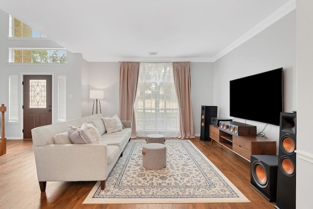 living room featuring visible vents, crown molding, baseboards, and wood finished floors