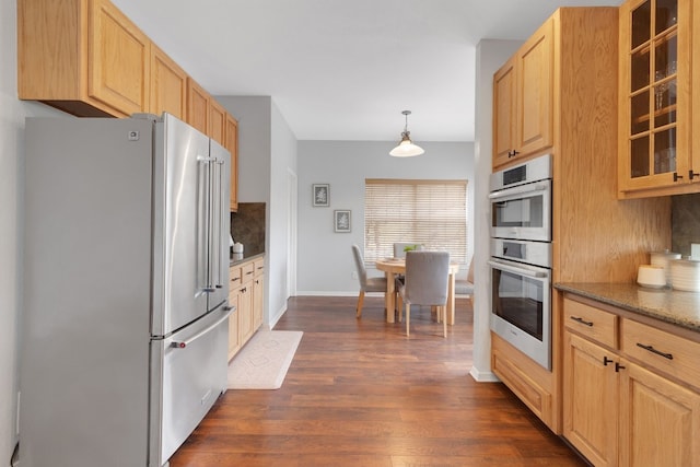 kitchen with decorative light fixtures, stainless steel appliances, glass insert cabinets, dark wood-type flooring, and light brown cabinets