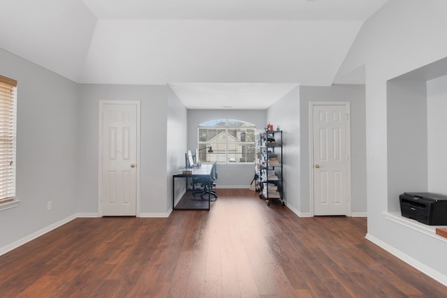 interior space with lofted ceiling, baseboards, and dark wood finished floors