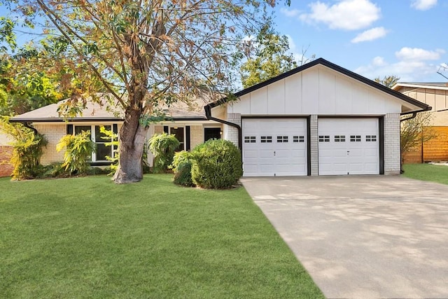 single story home with a garage, a front lawn, concrete driveway, and brick siding