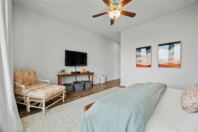 bedroom featuring ceiling fan, wood finished floors, visible vents, and baseboards