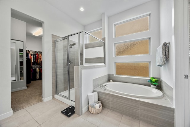 full bath with a shower stall, a walk in closet, a bath, and tile patterned floors