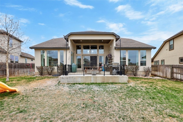 back of property with a patio area, a fenced backyard, and a yard