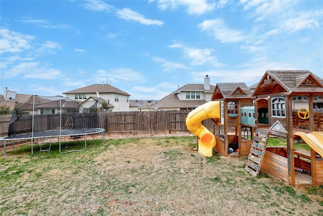 view of yard featuring a trampoline, fence, a playground, and a residential view