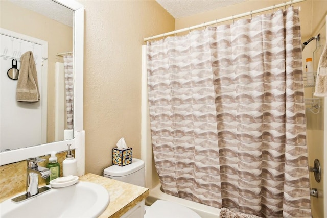 full bath with a textured wall, toilet, shower / bath combination with curtain, vanity, and a textured ceiling