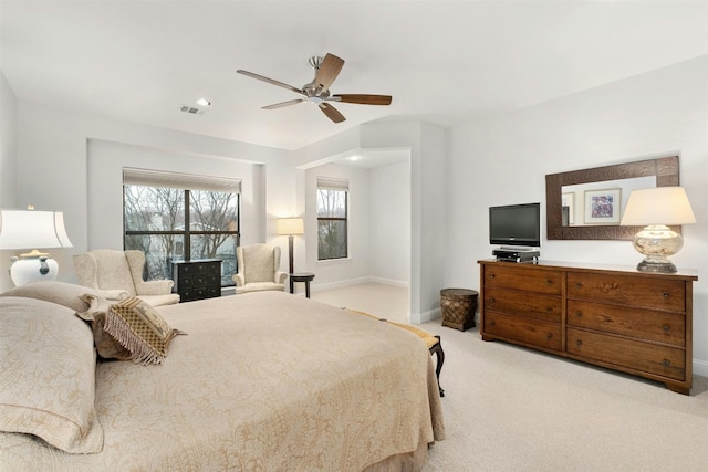 bedroom featuring light carpet, a ceiling fan, visible vents, and baseboards