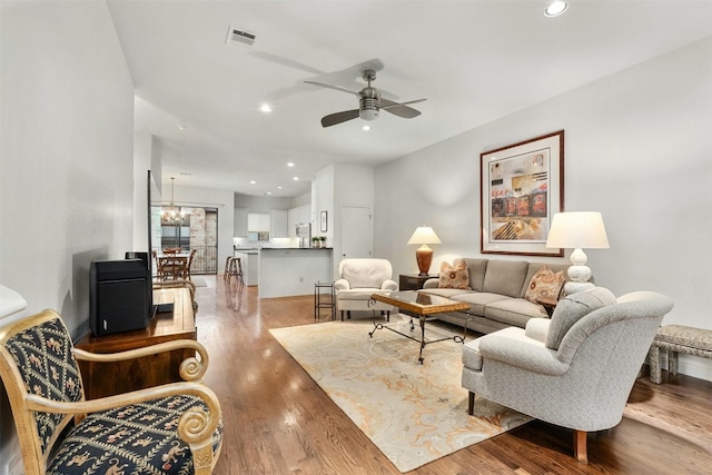 living room with recessed lighting, visible vents, wood finished floors, and ceiling fan with notable chandelier