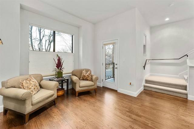 sitting room featuring a wealth of natural light, baseboards, light wood finished floors, and stairs