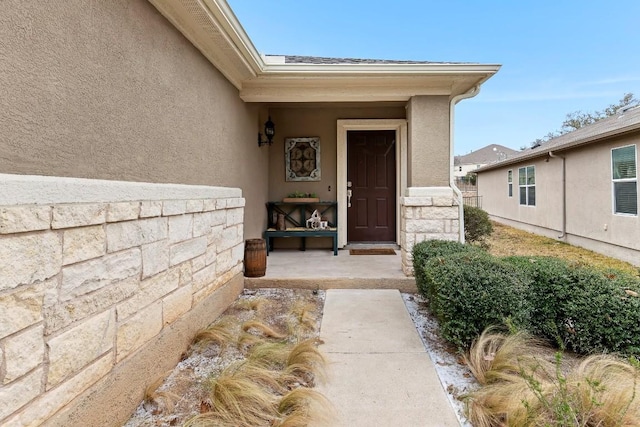 property entrance with stone siding and stucco siding