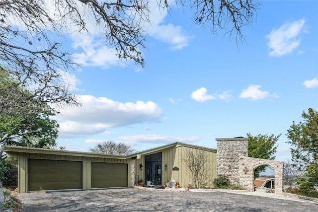 818 Mariner St, Lakeway, TX 78734 - mid-century inspired home featuring gravel driveway, an attached garage, and a chimney