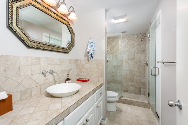 bathroom featuring toilet, a shower stall, tile patterned flooring, and vanity