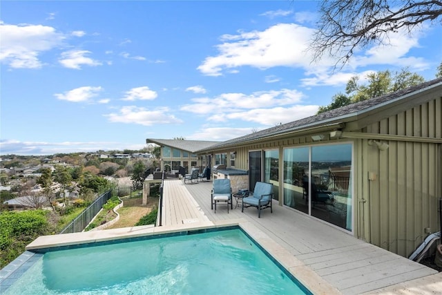 pool featuring fence and a deck