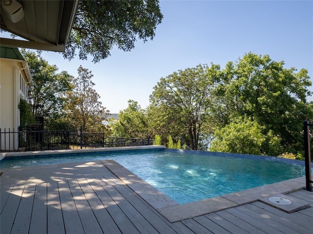 view of pool with an infinity pool and a wooden deck