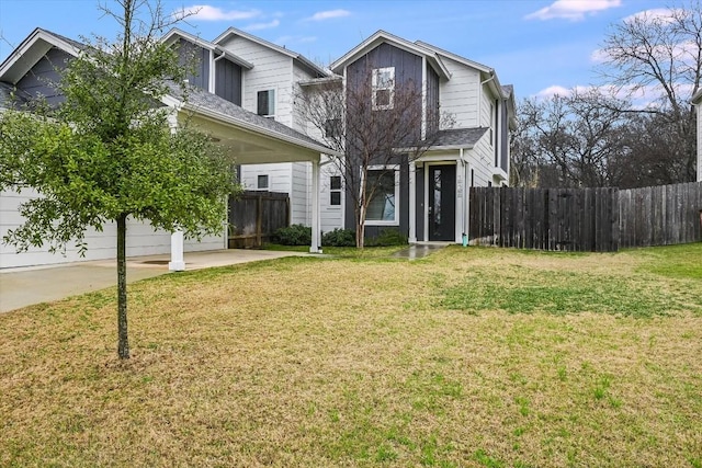 traditional home featuring a garage, fence, and a front yard