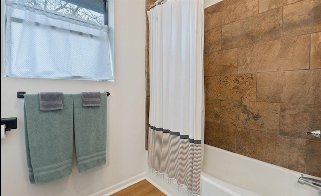 full bath with shower / bathtub combination with curtain, baseboards, and wood finished floors