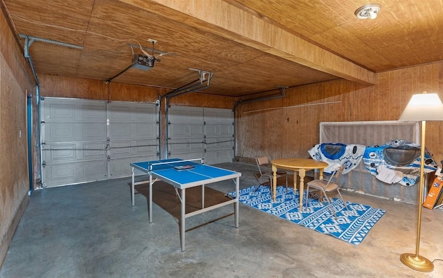 garage featuring wood ceiling, wooden walls, and a garage door opener