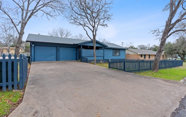 view of front of home featuring a garage, driveway, and a fenced front yard