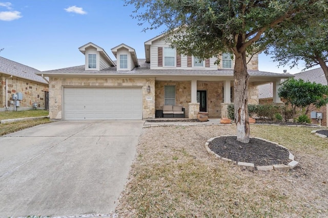 view of front of home featuring a porch, stone siding, an attached garage, and concrete driveway