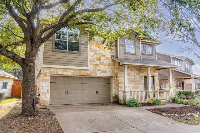 view of front of house featuring stone siding, concrete driveway, central AC, and a garage