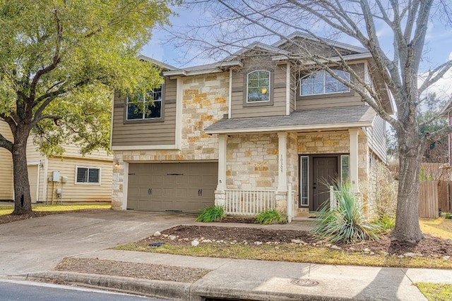 view of front facade featuring stone siding, driveway, an attached garage, and fence