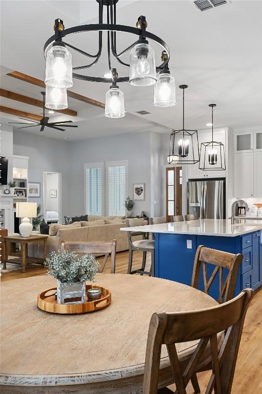 233 Lakefront Dr, Lago Vista, TX 78645 - kitchen featuring stainless steel refrigerator with ice dispenser, light countertops, light wood-style floors, and blue cabinetry