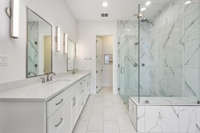 full bathroom with visible vents, a sink, a marble finish shower, and double vanity