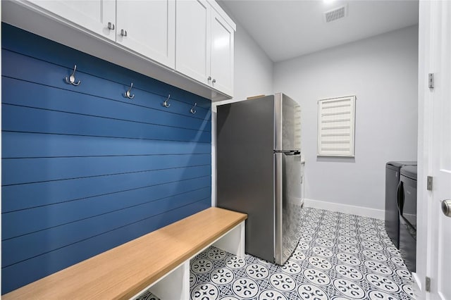 mudroom featuring light tile patterned floors, baseboards, visible vents, and independent washer and dryer