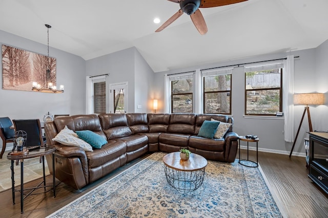 living area featuring baseboards, vaulted ceiling, dark wood finished floors, and ceiling fan with notable chandelier