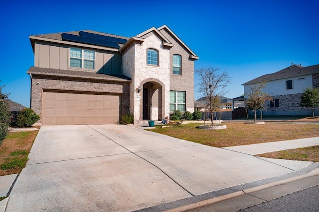 5864 Bianca Dr, Round Rock, TX 78665 - french country home with solar panels, board and batten siding, driveway, a garage, and brick siding