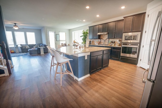 5864 Bianca Dr, Round Rock, TX 78665 - kitchen with stainless steel appliances, wood finished floors, a kitchen breakfast bar, and recessed lighting