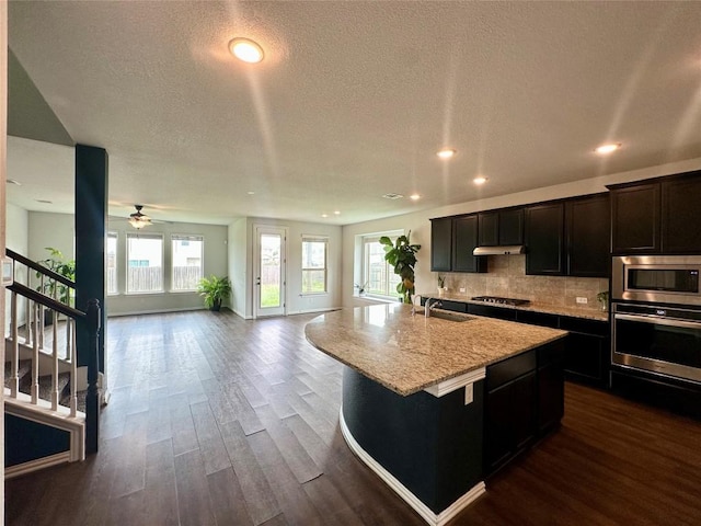5864 Bianca Dr, Round Rock, TX 78665 - kitchen with stainless steel appliances, open floor plan, recessed lighting, dark wood-type flooring, and decorative backsplash