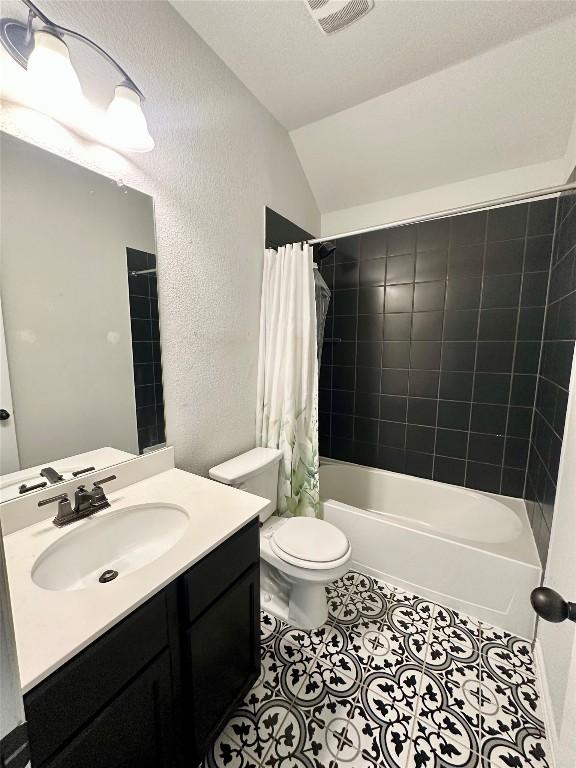 5864 Bianca Dr, Round Rock, TX 78665 - bathroom featuring vanity, a textured wall, lofted ceiling, tile patterned floors, and shower / bath combo