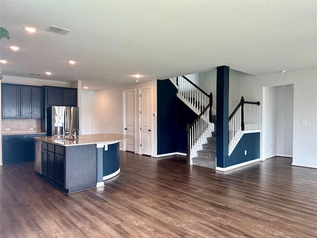 5864 Bianca Dr, Round Rock, TX 78665 - kitchen with stainless steel fridge, dark wood-style flooring, open floor plan, a center island with sink, and recessed lighting