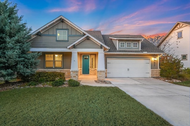 craftsman house featuring a garage, a lawn, concrete driveway, stone siding, and board and batten siding