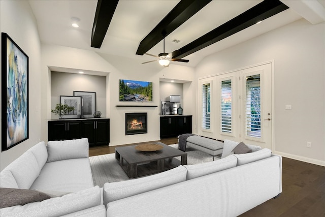 living room with a glass covered fireplace, visible vents, baseboards, and dark wood-style flooring