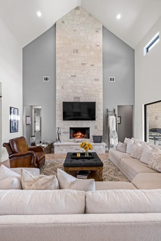 living room with visible vents, a fireplace, and wood finished floors