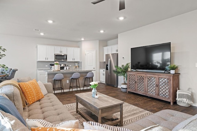 living room featuring a ceiling fan, visible vents, dark wood-type flooring, and recessed lighting