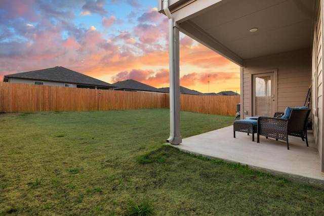 yard at dusk featuring a patio area and a fenced backyard