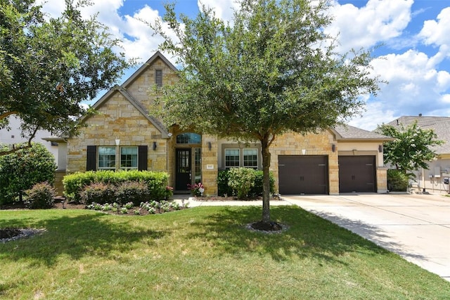 view of front of home featuring a garage, concrete driveway, stone siding, and a front lawn