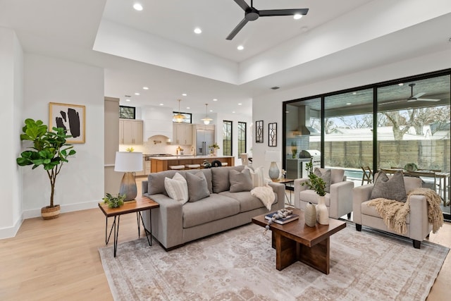 living area featuring ceiling fan, light wood finished floors, recessed lighting, and baseboards