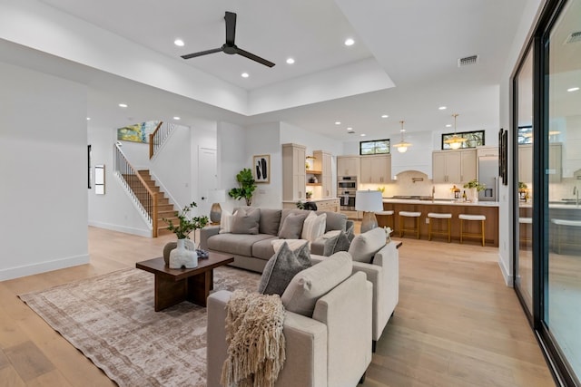 living room with recessed lighting, a ceiling fan, visible vents, stairway, and light wood finished floors