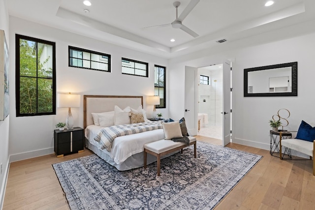 bedroom with multiple windows, a raised ceiling, and visible vents