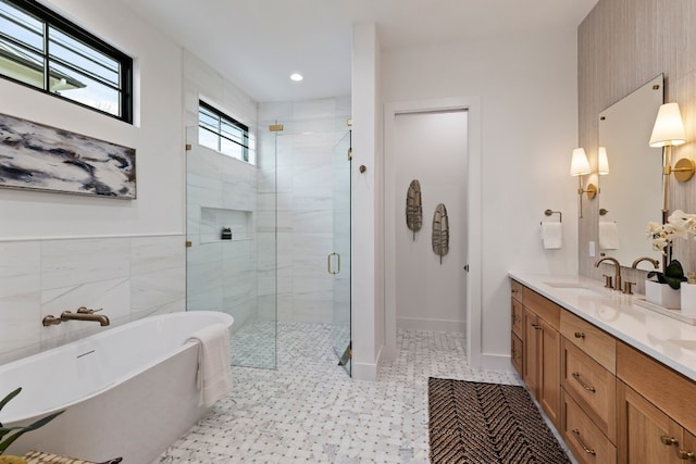 bathroom with vanity, baseboards, a freestanding bath, tile walls, and a shower stall