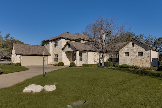 french provincial home featuring a garage, driveway, stone siding, and a front yard