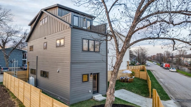 view of side of home with board and batten siding and fence