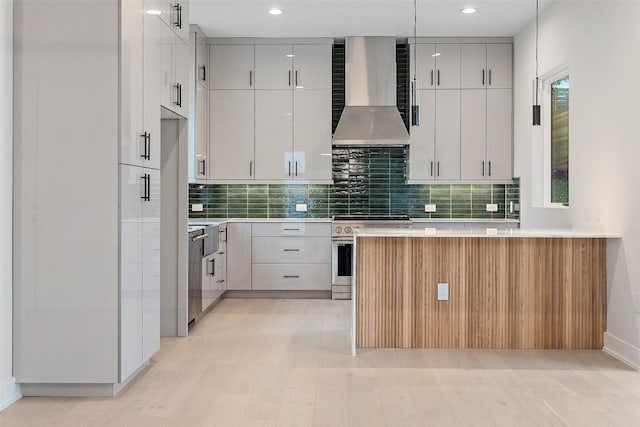 1135 Salina St, Austin, TX 78702 - kitchen with wall chimney exhaust hood, stainless steel gas stove, tasteful backsplash, light countertops, and recessed lighting