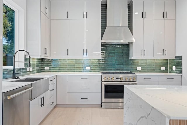 1135 Salina St, Austin, TX 78702 - kitchen featuring appliances with stainless steel finishes, wall chimney range hood, light stone counters, and white cabinets
