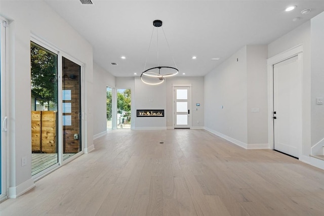 1135 Salina St, Austin, TX 78702 - unfurnished living room with light wood finished floors, baseboards, and recessed lighting
