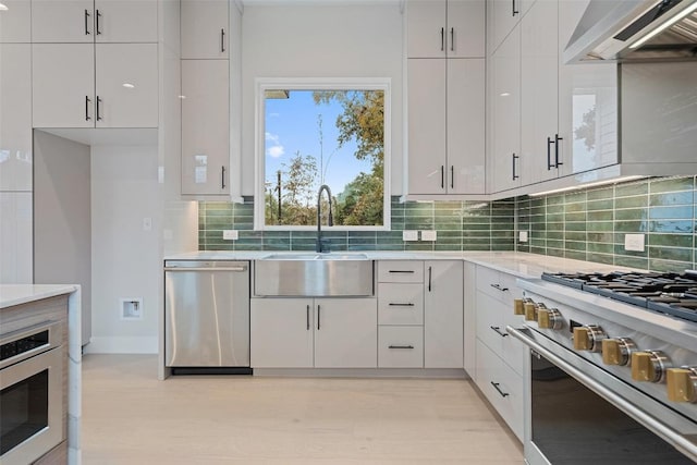 1135 Salina St, Austin, TX 78702 - kitchen with stainless steel appliances, wall chimney range hood, a sink, and backsplash