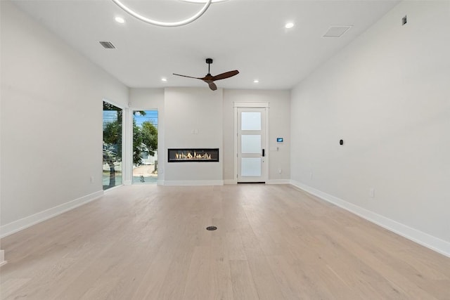 1135 Salina St, Austin, TX 78702 - unfurnished living room featuring recessed lighting, a glass covered fireplace, ceiling fan, light wood finished floors, and baseboards